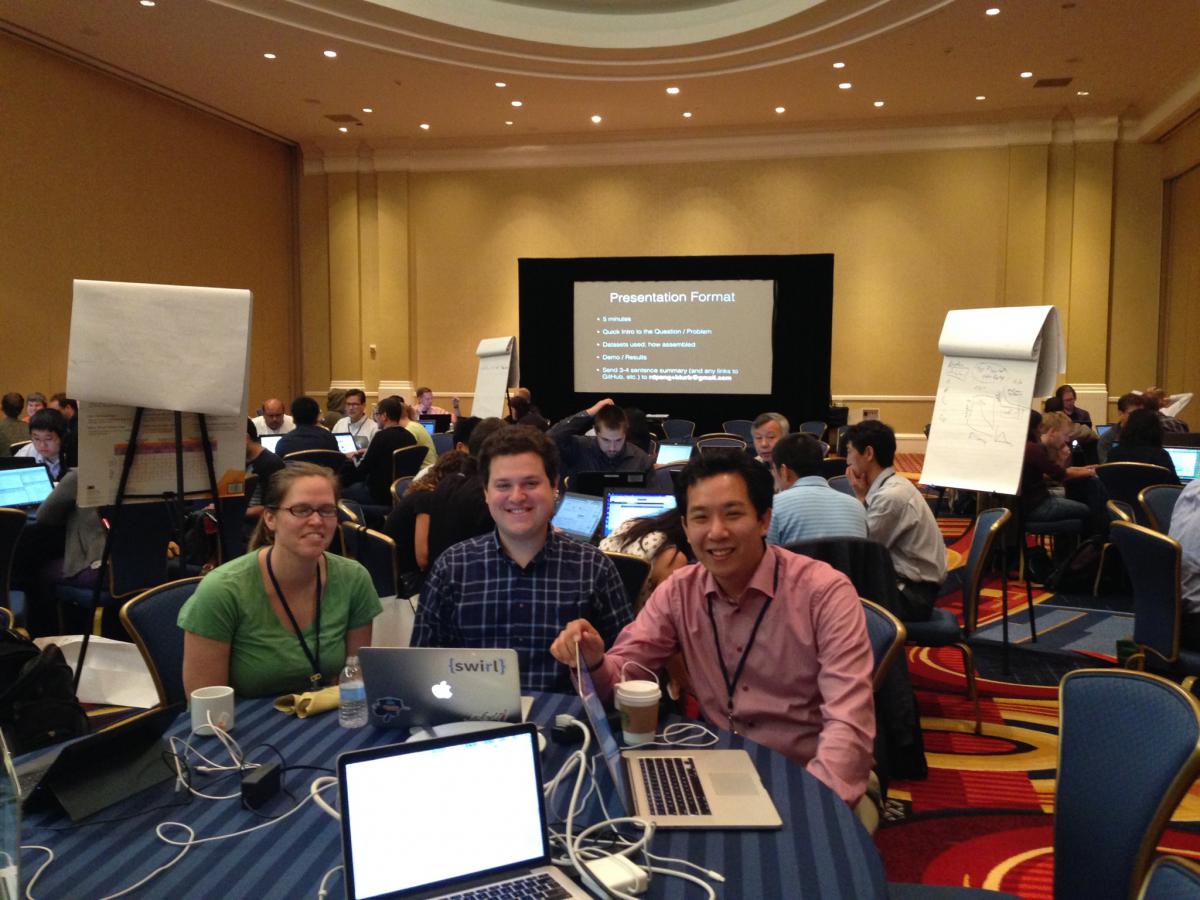 This is a picture of the JHU-NIH Hackathon with the primary organizers in the foreground and students working in the background.