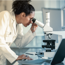 person looking into microscope
