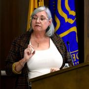 Dr. Susan Gregurick stands at a podium giving a talk at NIEHS.